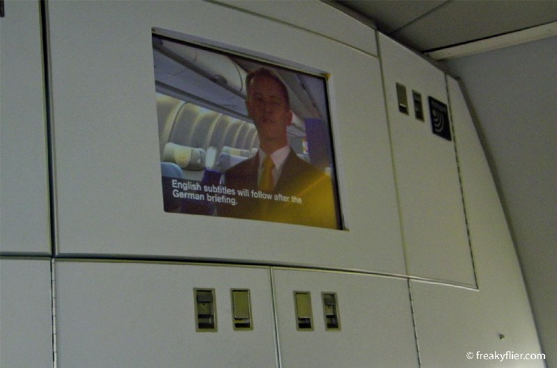 Lufthansa pre-flight safety briefing delivered in German and English with subtitles for both