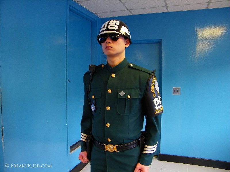 South Korean soldier stands guard at the northern door inside the blue building conference room